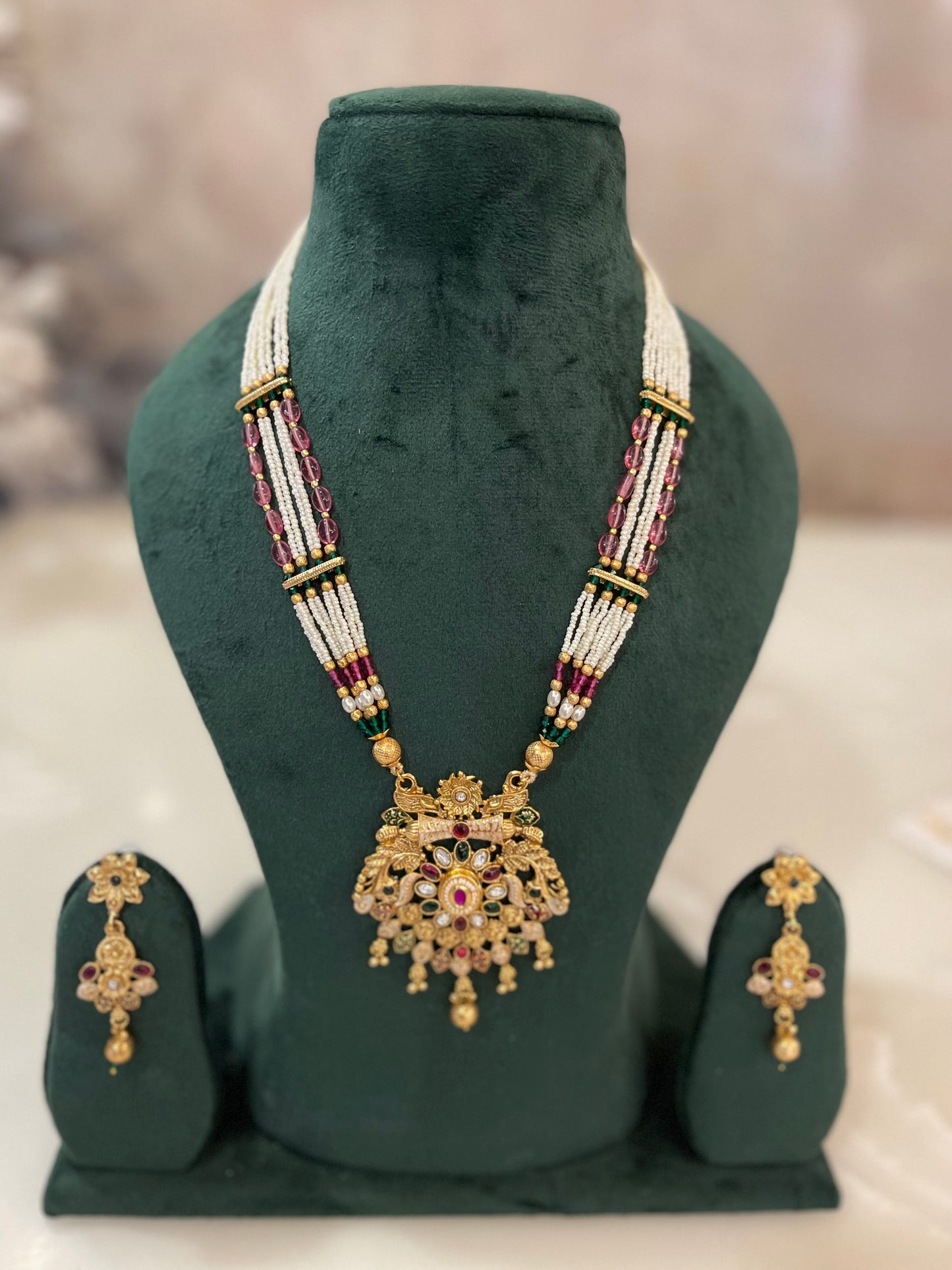Golden necklace with red and white beads.