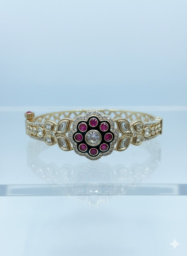 Golden bracelet with a decorative center featuring red stones