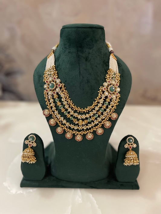 Golden necklace with green stones and matching earrings.