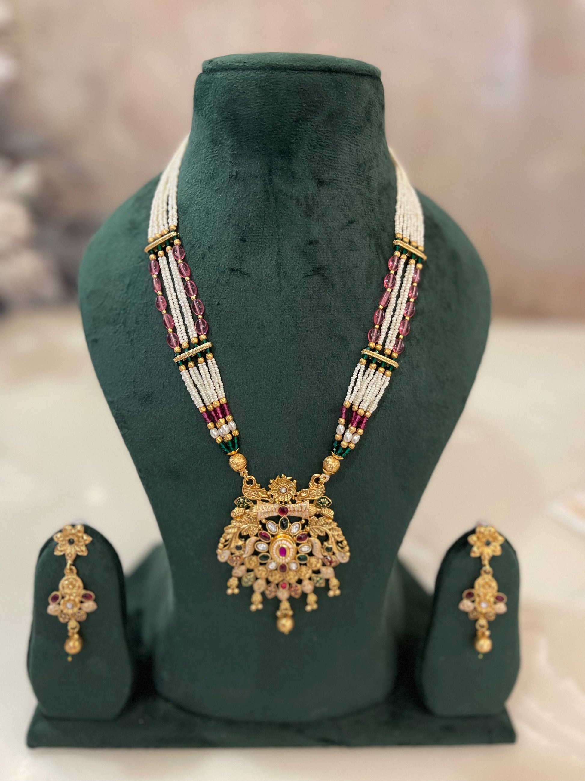 Golden necklace with red and white beads.