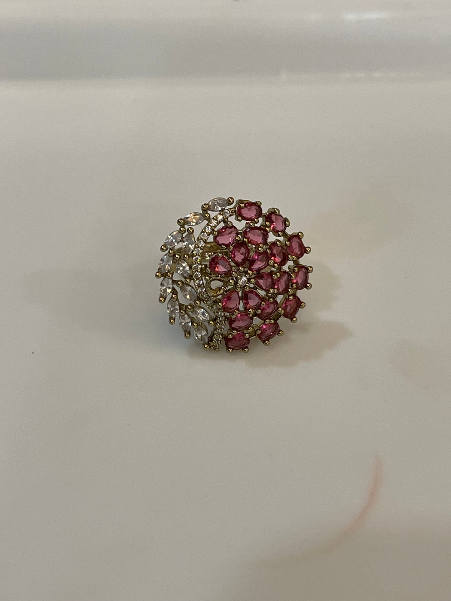 Jewelry ring with pink gemstones and a gold band 