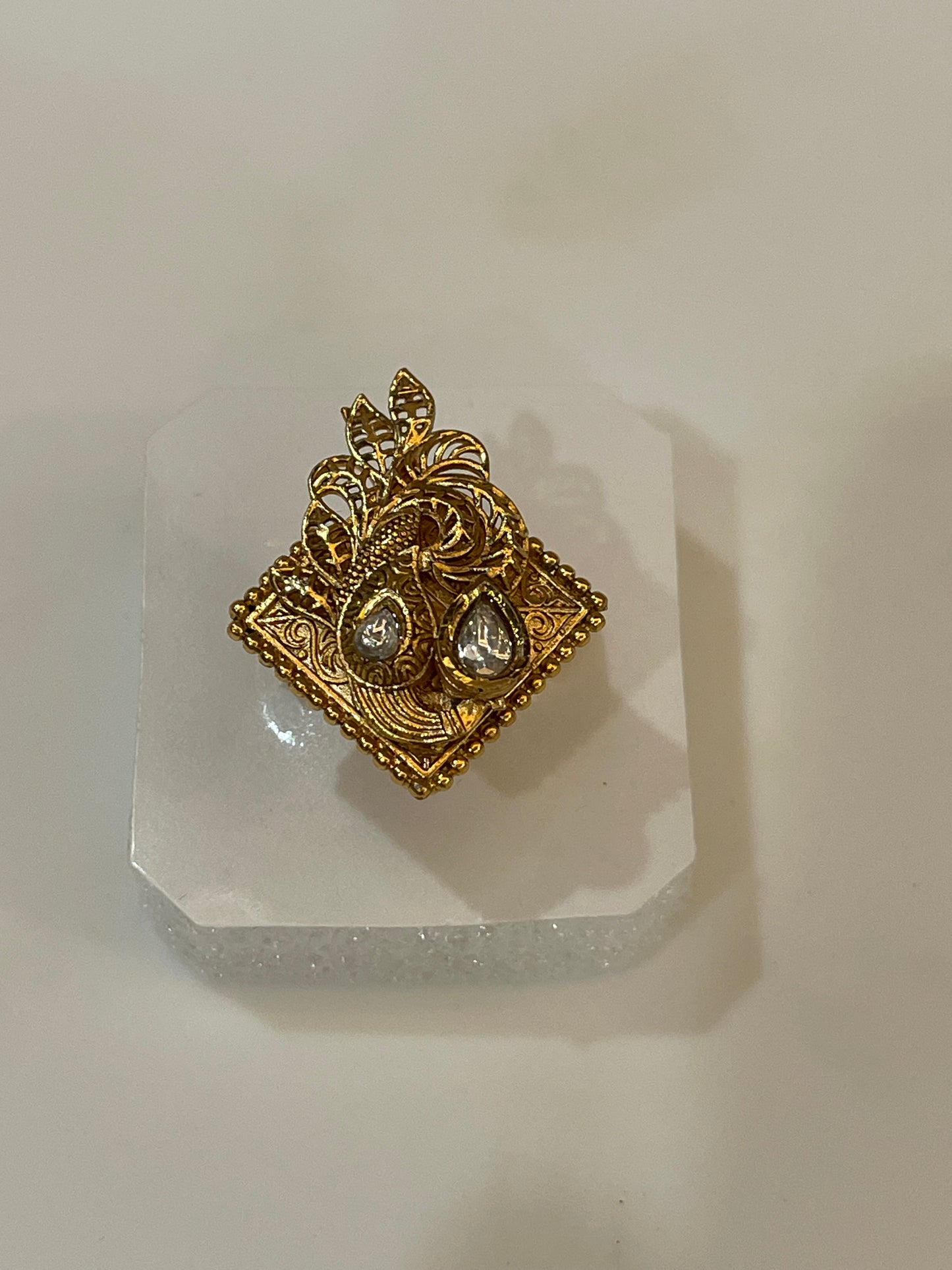 Golden ring with intricate design studded with petal shaped stones