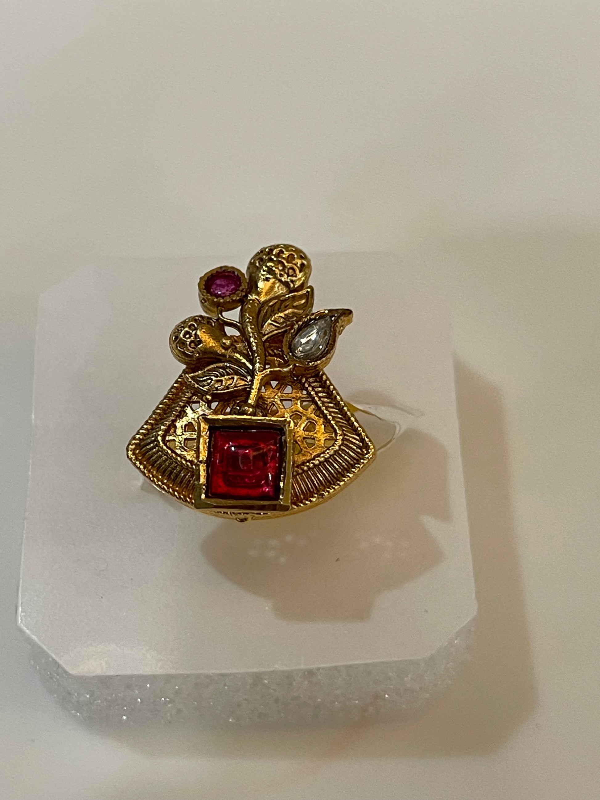 Golden ring with red and white gemstone
