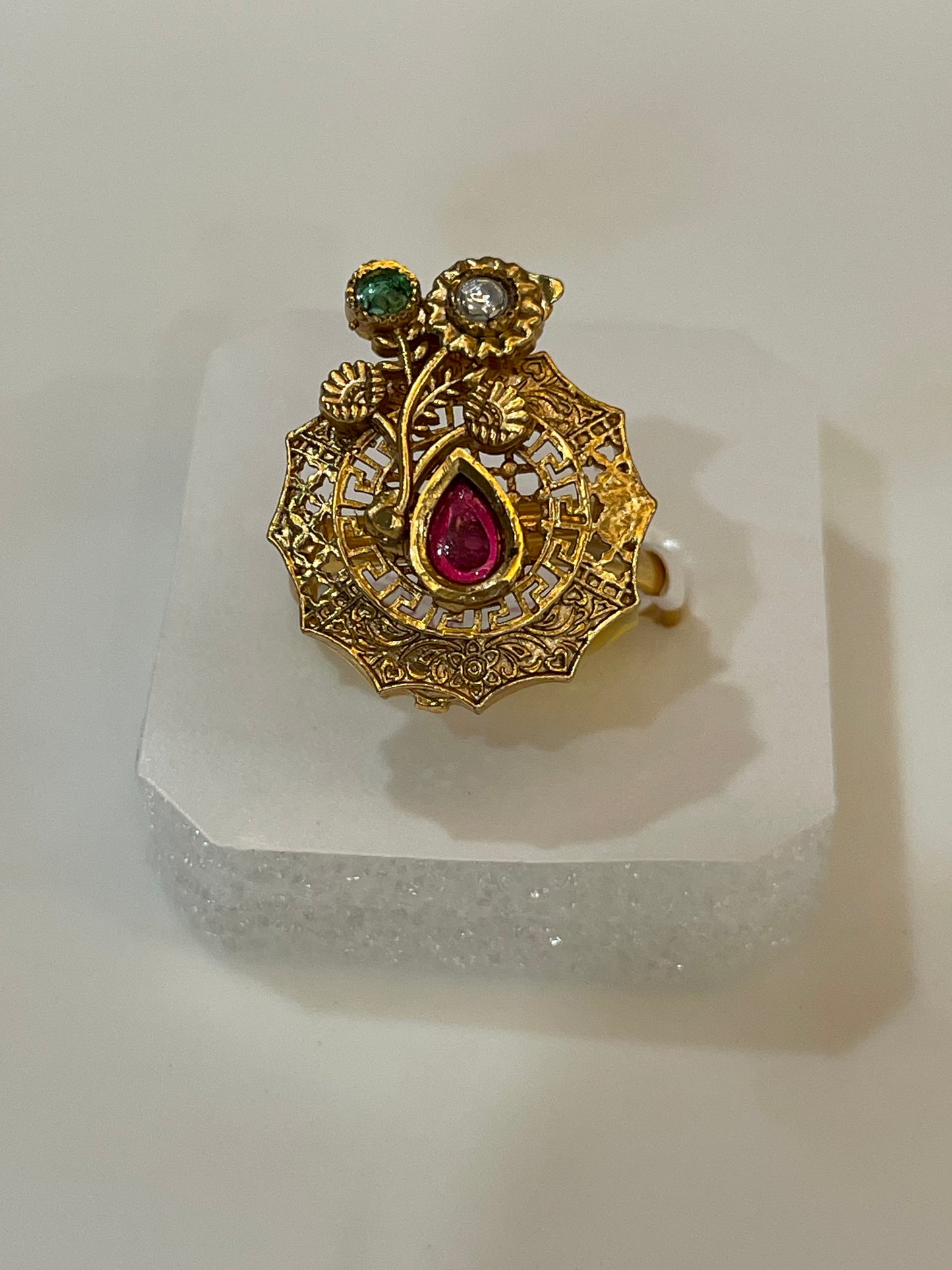 Golden ring with red white and green gemstones in petal shape