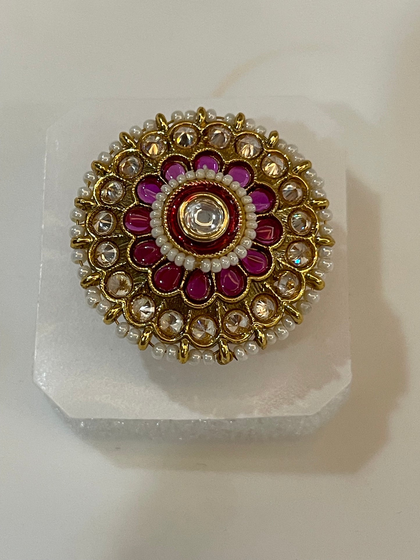 Golden Kundan ring with gold, red, and white stones design.