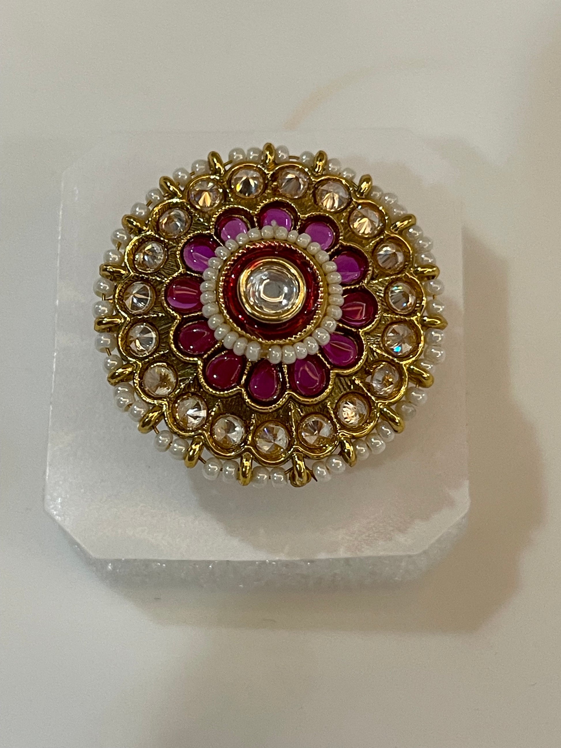 Golden Kundan ring with gold, red, and white stones design.