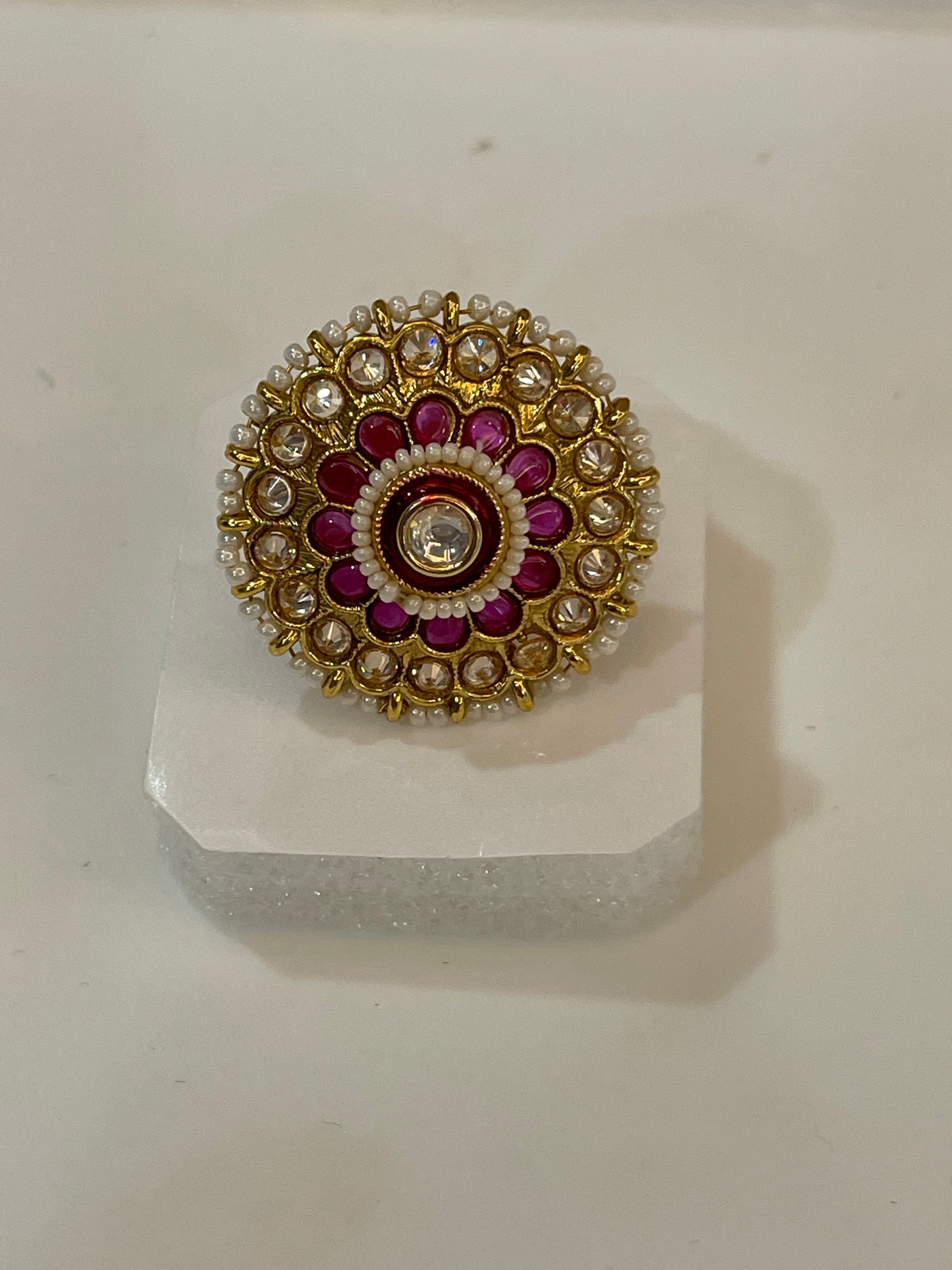 Golden Kundan ring with gold, red, and white stones design.