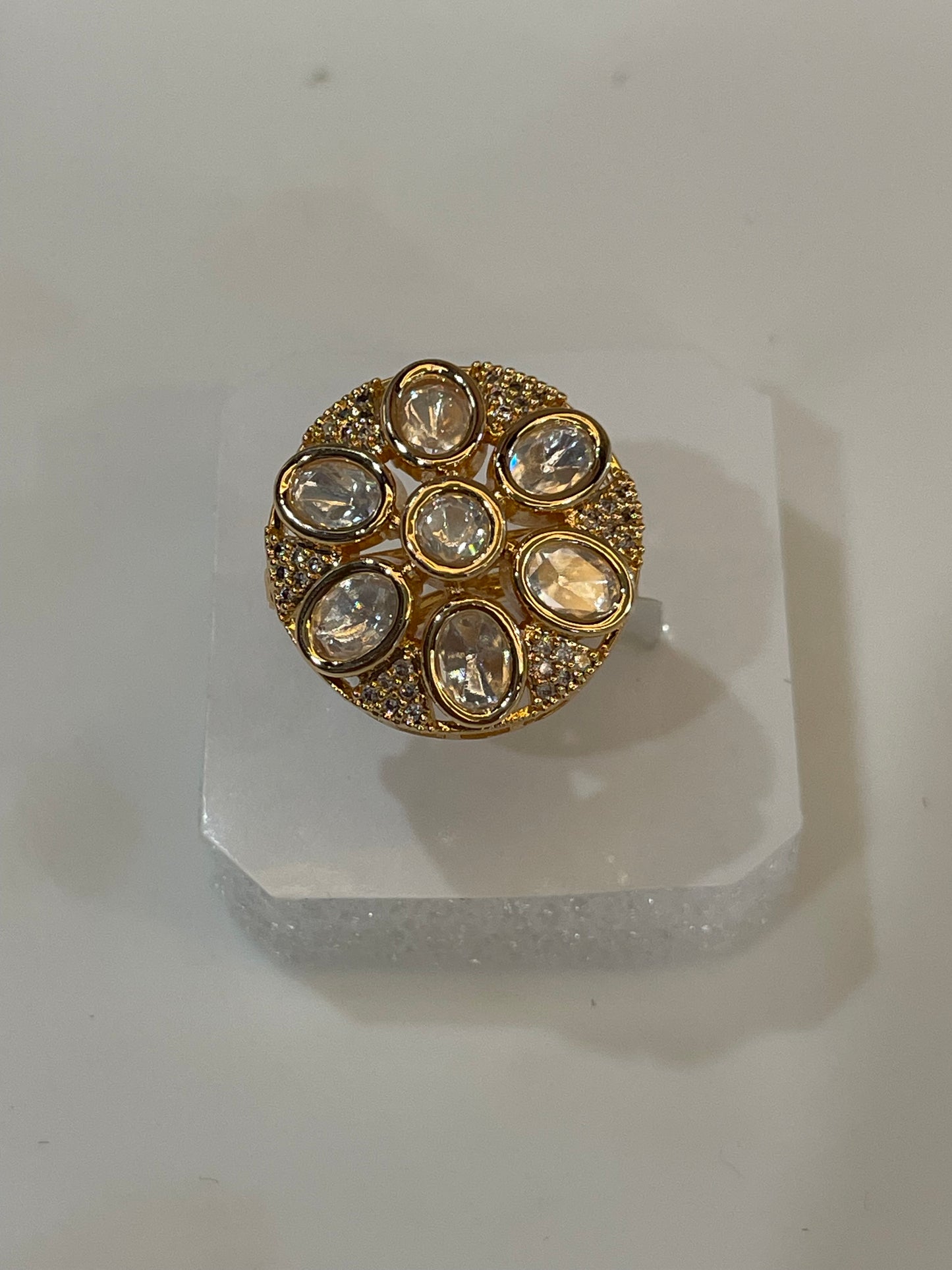 Golden cocktail ring with clear gemstones.