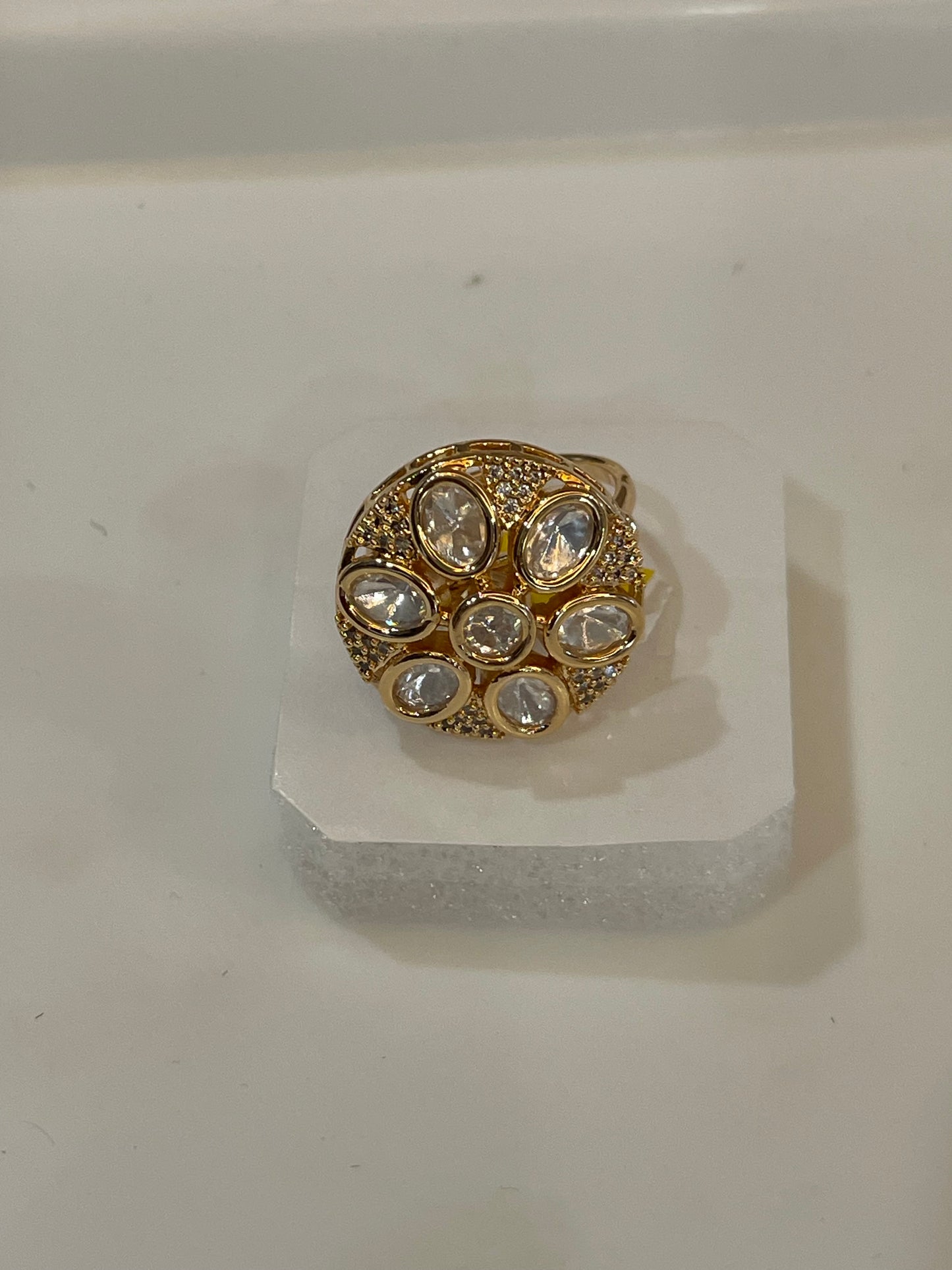 Golden cocktail ring with clear gemstones.