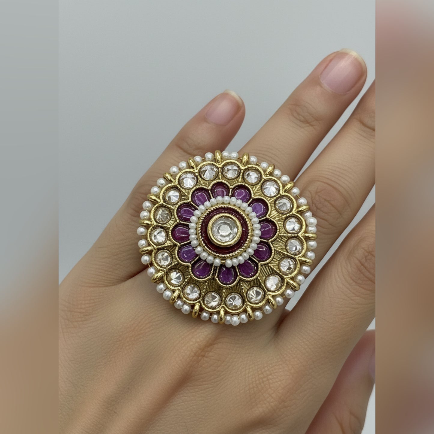 Golden Kundan ring with gold, red, and white stones design.